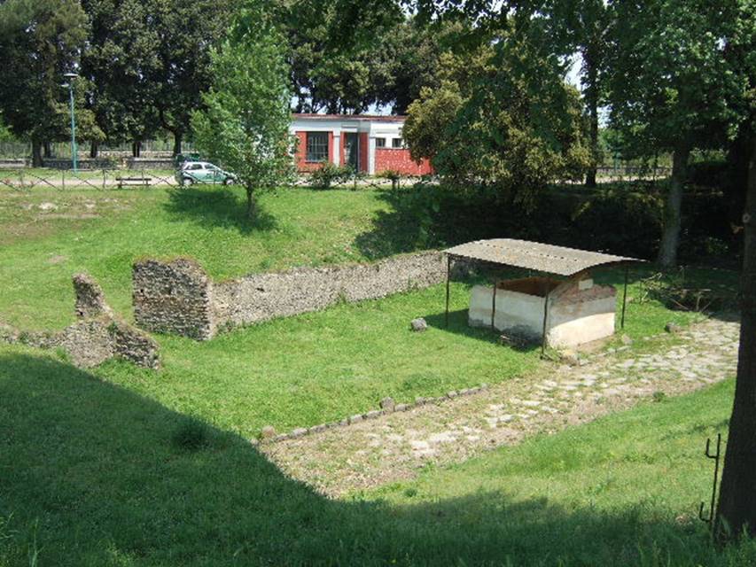 NGOF Pompeii. May 2006. Tomb of M. Obellius Firmus and ancient roadway running past the front.

An ancient wall is to the rear with a gateway in it. In front of this is the area where fifteen bodies were found and casts taken.

See De Caro, S., 1979. Scavi nell'area fuori Porta Nola a Pompei in Cronache Pompeiane V. p. 95-101, figs. 25, 26.